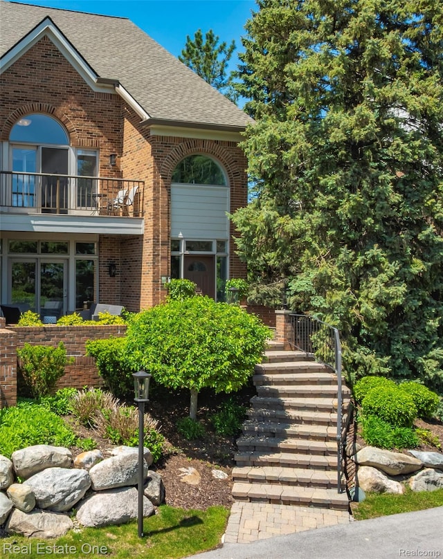 3856 Pine Lake Knoll Dr, West Bloomfield, MI 48324 - doorway to property featuring brick siding, roof with shingles, and a balcony