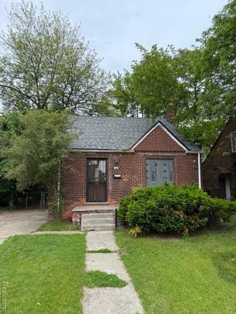 19537 Hamburg St, Detroit, MI 48205 - view of front of home featuring brick siding, a front lawn, and roof with shingles