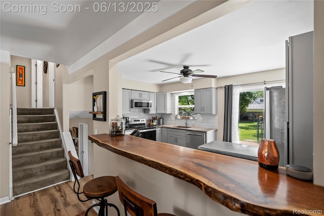 6615 Hatchery Rd, Waterford, MI 48327 - kitchen featuring stainless steel appliances, wooden counters, backsplash, and a sink