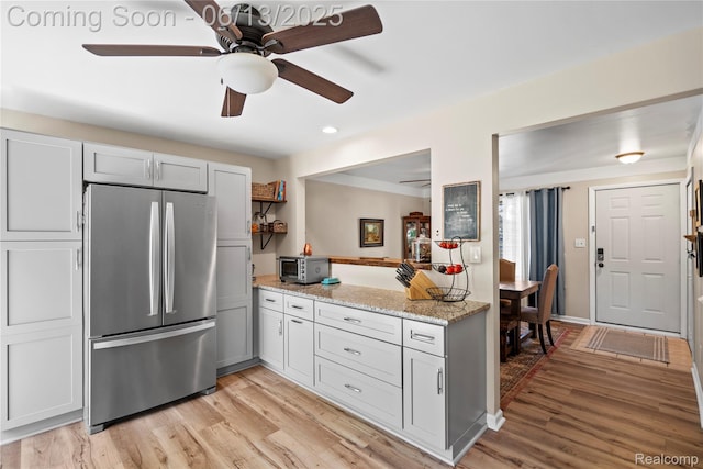 6615 Hatchery Rd, Waterford, MI 48327 - kitchen featuring freestanding refrigerator, ceiling fan, light wood-style floors, light stone countertops, and recessed lighting