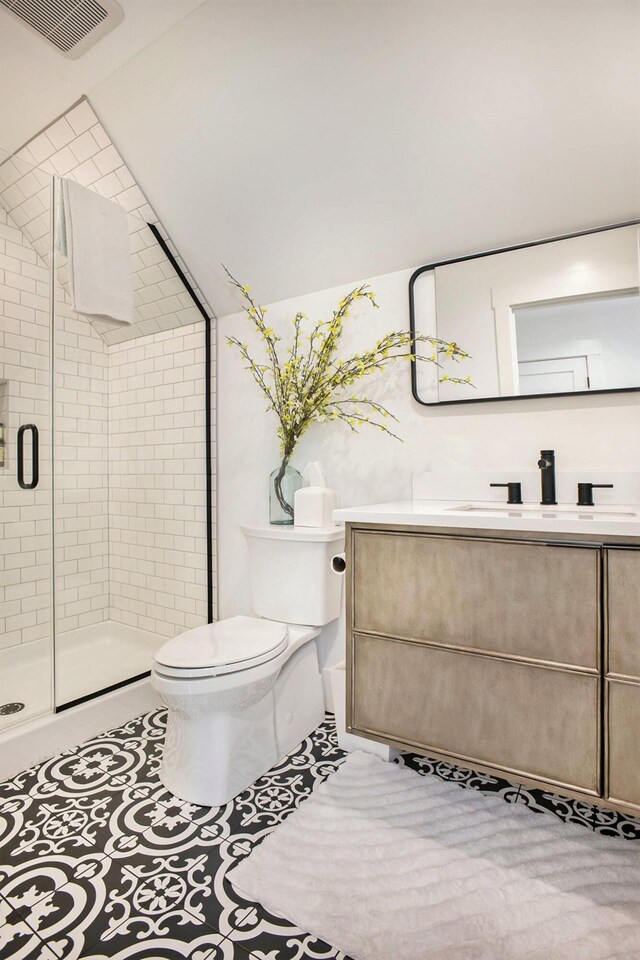 2958 S Edgar Rd, Mason, MI 48854 - bathroom with toilet, vanity, a shower stall, tile patterned floors, and vaulted ceiling
