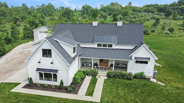2958 S Edgar Rd, Mason, MI 48854 - modern farmhouse with a standing seam roof, roof with shingles, a front lawn, a chimney, and metal roof