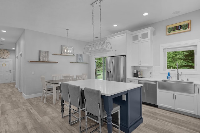 1304 Michillinda Rd, Muskegon, MI 49445 - kitchen featuring appliances with stainless steel finishes, a sink, light wood-style floors, light countertops, and recessed lighting