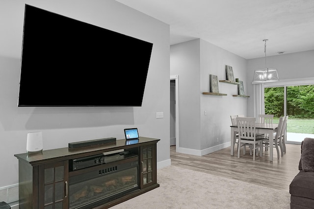 1304 Michillinda Rd, Muskegon, MI 49445 - living room with baseboards, a chandelier, and wood finished floors