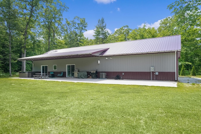 1304 Michillinda Rd, Muskegon, MI 49445 - rear view of house with cooling unit, a lawn, a patio area, and metal roof