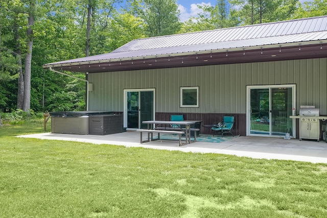 1304 Michillinda Rd, Muskegon, MI 49445 - rear view of house featuring a patio area, a lawn, metal roof, and a hot tub
