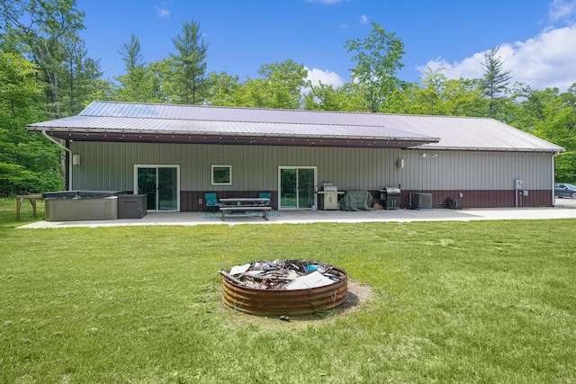 1304 Michillinda Rd, Muskegon, MI 49445 - back of property featuring a patio, a yard, a hot tub, metal roof, and cooling unit