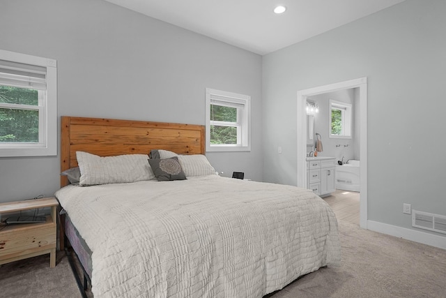 1304 Michillinda Rd, Muskegon, MI 49445 - bedroom featuring light carpet, ensuite bath, and baseboards