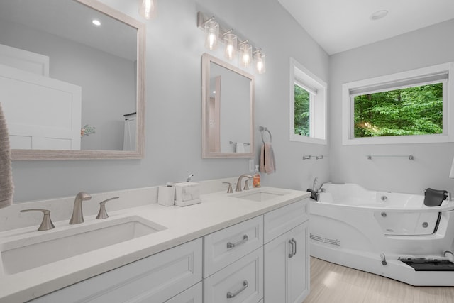 1304 Michillinda Rd, Muskegon, MI 49445 - bathroom featuring double vanity, a whirlpool tub, and recessed lighting