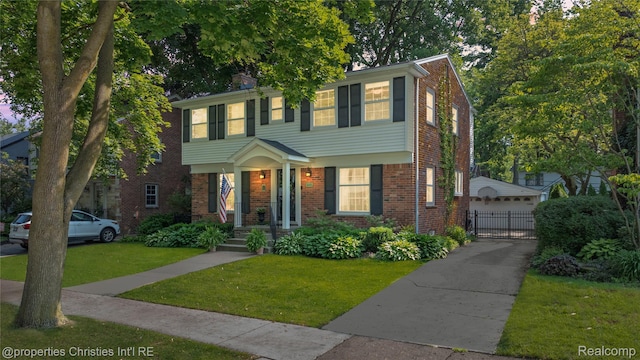 713 Claremont St, Dearborn, MI 48124 - colonial home with brick siding, a garage, a gate, and an outdoor structure