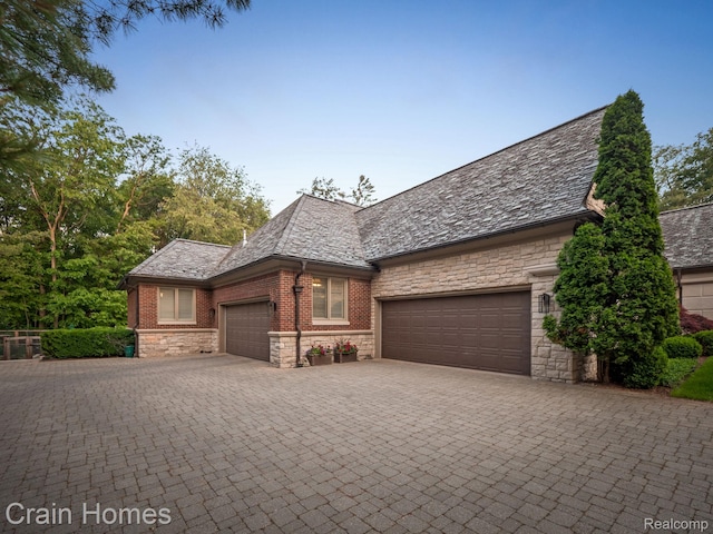 20 Hidden Rdg, Bloomfield Hills, MI 48304 - view of front of home with stone siding, a high end roof, a garage, and driveway