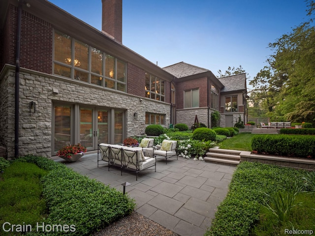 20 Hidden Rdg, Bloomfield Hills, MI 48304 - back of house featuring stone siding, a patio, an outdoor hangout area, and a chimney