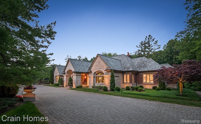 20 Hidden Rdg, Bloomfield Hills, MI 48304 - view of front facade with stone siding, decorative driveway, a chimney, and a high end roof