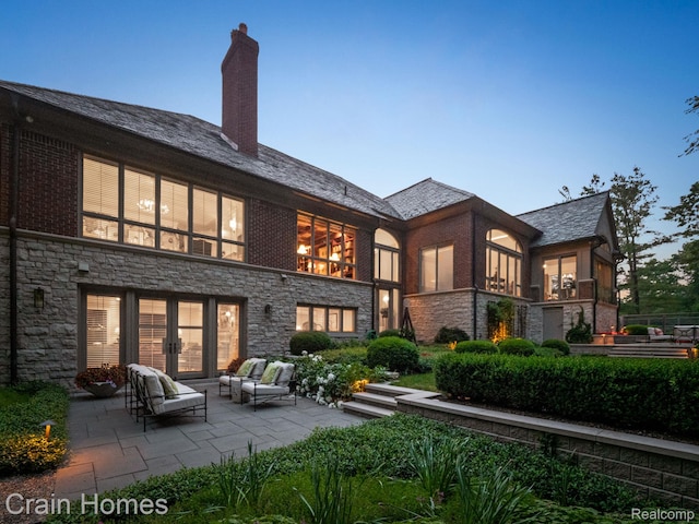 20 Hidden Rdg, Bloomfield Hills, MI 48304 - back of house with stone siding, a patio, an outdoor living space, a chimney, and a high end roof