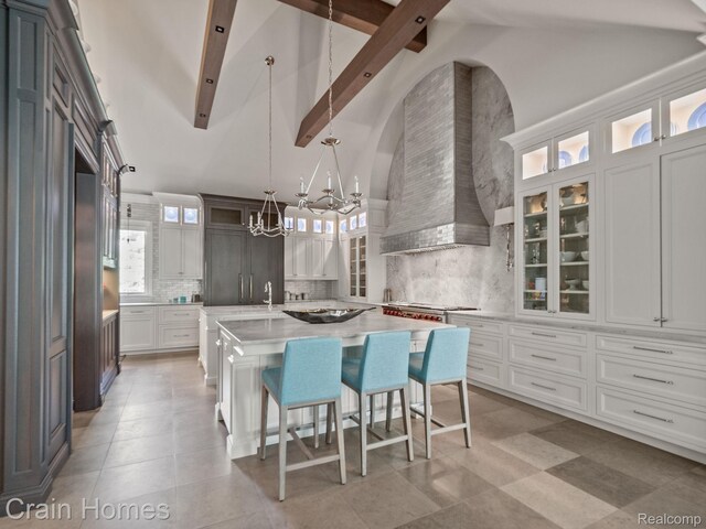 20 Hidden Rdg, Bloomfield Hills, MI 48304 - kitchen with light countertops, a kitchen island with sink, a chandelier, high vaulted ceiling, and backsplash