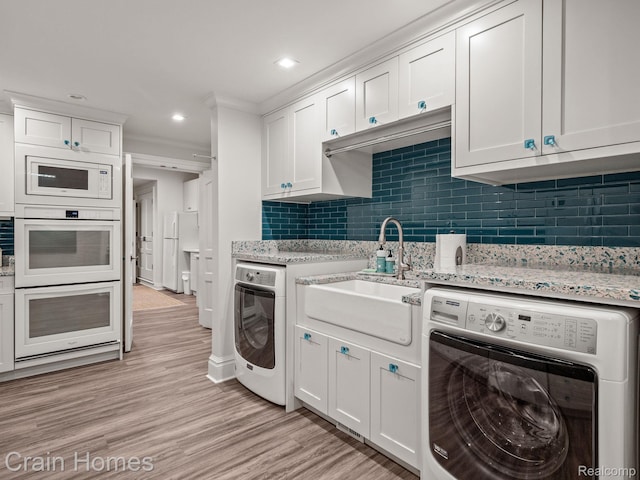 20 Hidden Rdg, Bloomfield Hills, MI 48304 - kitchen featuring washer / dryer, a sink, white appliances, white cabinetry, and recessed lighting