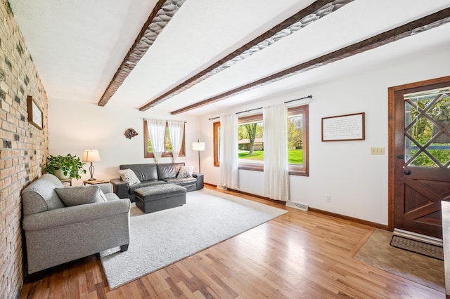 2794 W Park Ln, Benton Harbor, MI 49022 - living area featuring healthy amount of natural light, light wood-style flooring, beamed ceiling, baseboards, and brick wall