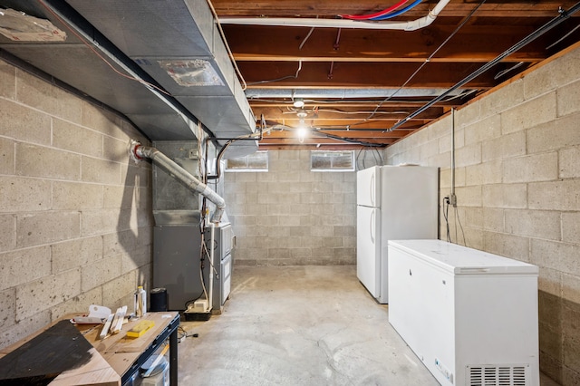 2794 W Park Ln, Benton Harbor, MI 49022 - unfinished basement with white refrigerator, freestanding refrigerator, and heating unit