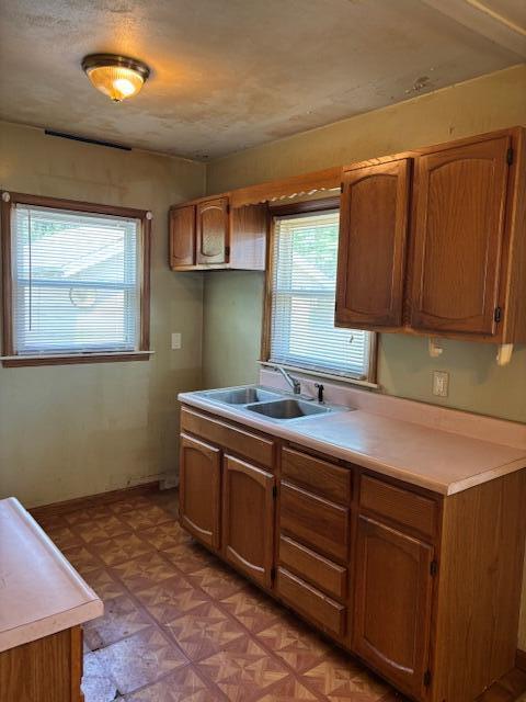 408 Hill St, Buchanan, MI 49107 - kitchen with a sink, light countertops, brown cabinets, and baseboards