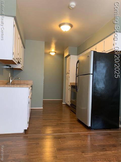 2041 N Arbor Way Dr Unit 71, Canton, MI 48188 - kitchen with freestanding refrigerator, stove, white cabinets, light countertops, and dark wood-style floors
