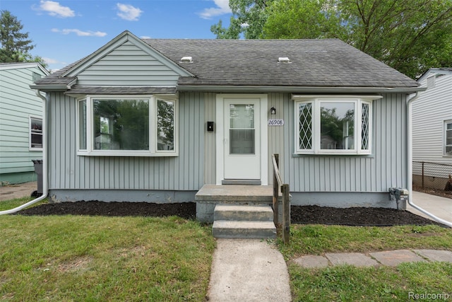 26908 Kitch St, Inkster, MI 48141 - bungalow-style house featuring a shingled roof, board and batten siding, and a front lawn