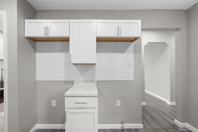 26908 Kitch St, Inkster, MI 48141 - kitchen with backsplash, dark wood-style flooring, white cabinetry, and baseboards