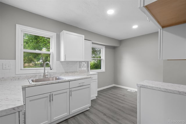 26908 Kitch St, Inkster, MI 48141 - kitchen featuring a sink, white cabinets, decorative backsplash, light wood-style flooring, and recessed lighting
