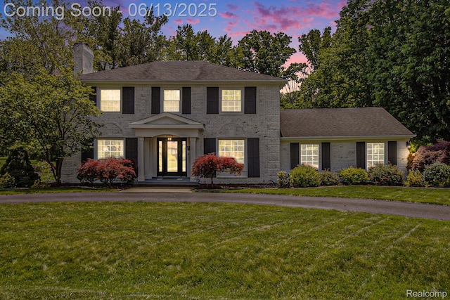 9875 Island Dr, Grosse Ile, MI 48138 - view of front of property featuring brick siding, a chimney, and a lawn