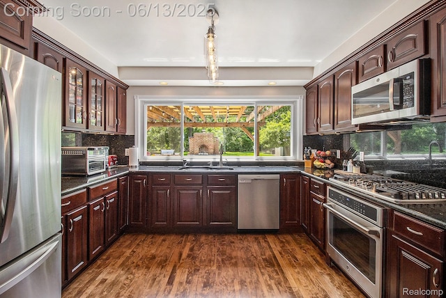 9875 Island Dr, Grosse Ile, MI 48138 - kitchen with stainless steel appliances, dark countertops, tasteful backsplash, and dark wood-type flooring