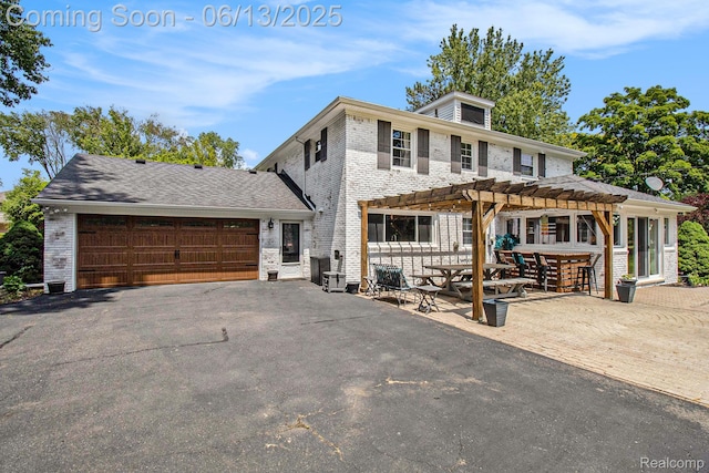 9875 Island Dr, Grosse Ile, MI 48138 - view of front of home featuring a pergola, brick siding, an attached garage, and asphalt driveway