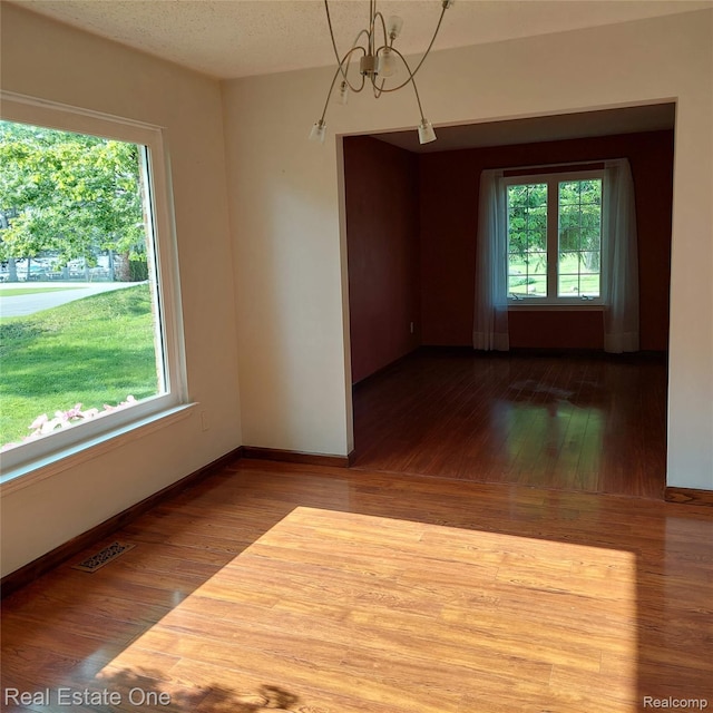 5208 Woodview Dr, Bloomfield Hills, MI 48302 - empty room featuring hardwood / wood-style flooring and a chandelier