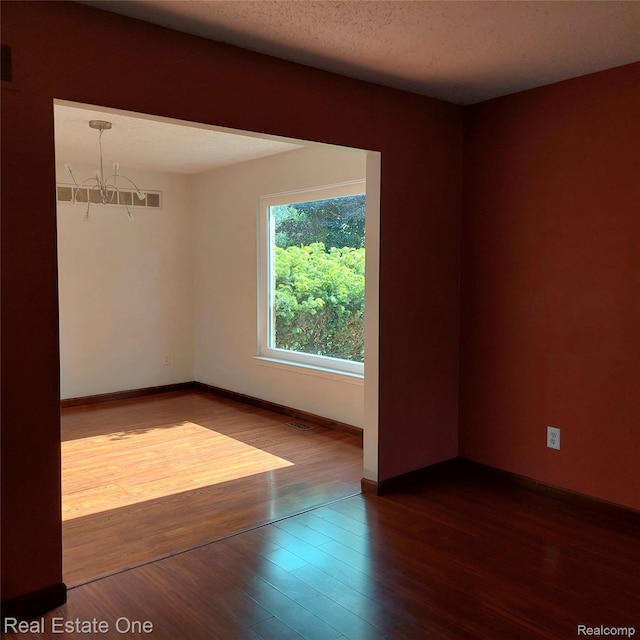 5208 Woodview Dr, Bloomfield Hills, MI 48302 - empty room with a chandelier and dark wood-style flooring