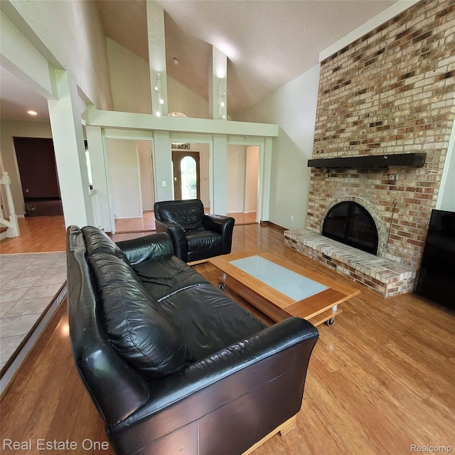 5208 Woodview Dr, Bloomfield Hills, MI 48302 - living room featuring wood finished floors, a brick fireplace, and high vaulted ceiling