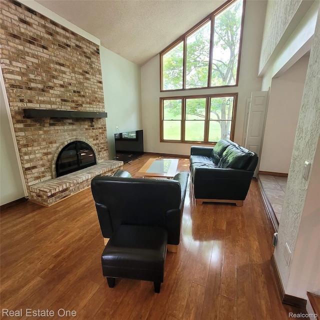 5208 Woodview Dr, Bloomfield Hills, MI 48302 - living room with high vaulted ceiling, hardwood / wood-style floors, a fireplace, and a textured ceiling