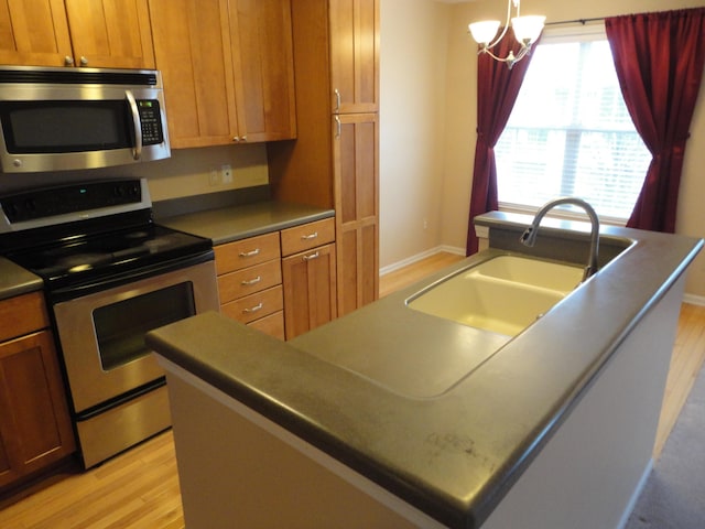 2856 Barclay Way, Ann Arbor, MI 48105 - kitchen with stainless steel appliances, light wood-style floors, an island with sink, and a sink