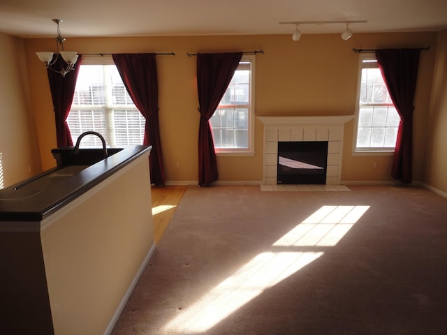 2856 Barclay Way, Ann Arbor, MI 48105 - living room featuring rail lighting, light colored carpet, a tiled fireplace, and baseboards