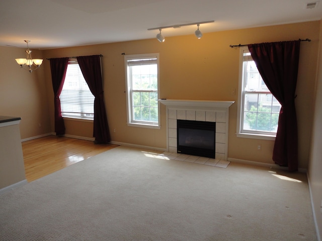 2856 Barclay Way, Ann Arbor, MI 48105 - unfurnished living room featuring carpet floors, a chandelier, track lighting, a fireplace, and baseboards