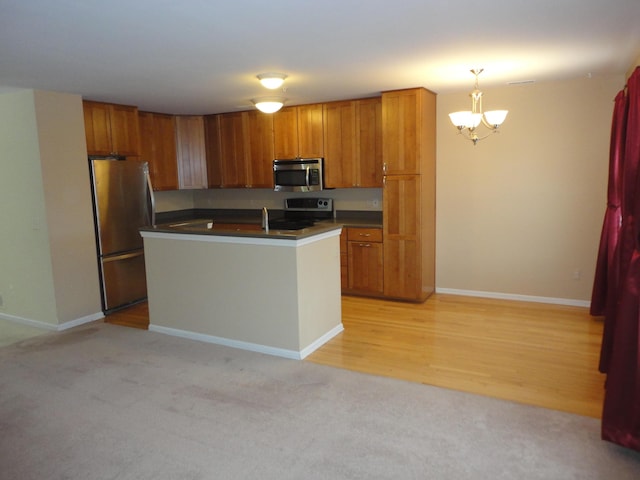 2856 Barclay Way, Ann Arbor, MI 48105 - kitchen featuring stainless steel appliances, dark countertops, a chandelier, and brown cabinetry