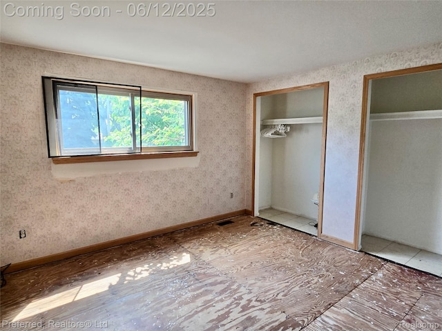9498 Bassett St, Livonia, MI 48150 - unfurnished bedroom with two closets and baseboards