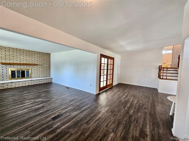 9498 Bassett St, Livonia, MI 48150 - unfurnished living room with dark wood-style flooring and a brick fireplace