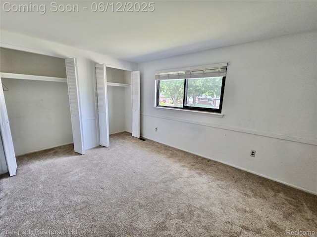 9498 Bassett St, Livonia, MI 48150 - unfurnished bedroom featuring multiple closets and carpet flooring