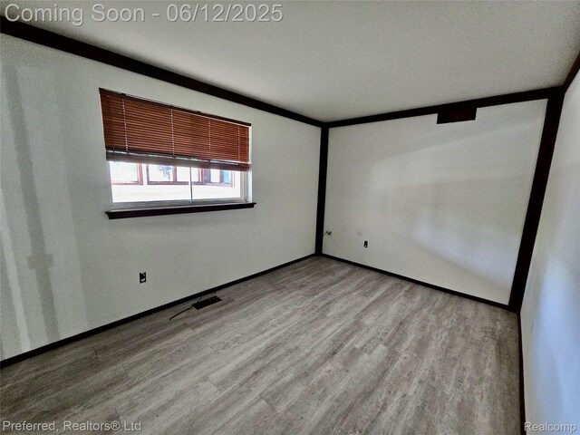 9498 Bassett St, Livonia, MI 48150 - spare room with wood finished floors and baseboards