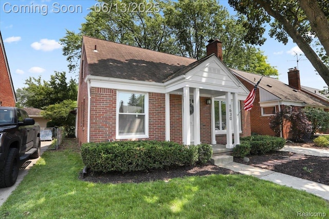 1630 N Denwood St, Dearborn, MI 48128 - view of front of home with brick siding, a front lawn, a chimney, and a shingled roof