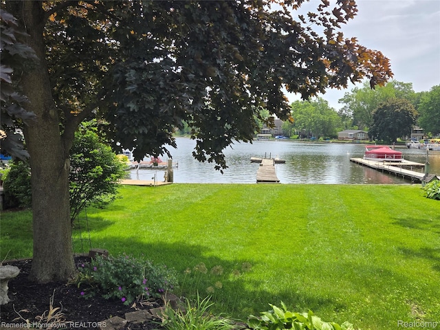 8991 Lakeview Dr, White Lake, MI 48386 - view of green lawn with a water view and a boat dock