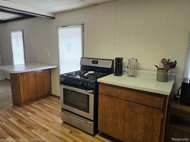 8991 Lakeview Dr, White Lake, MI 48386 - kitchen with stainless steel range with gas stovetop, a peninsula, light wood-style floors, and light countertops