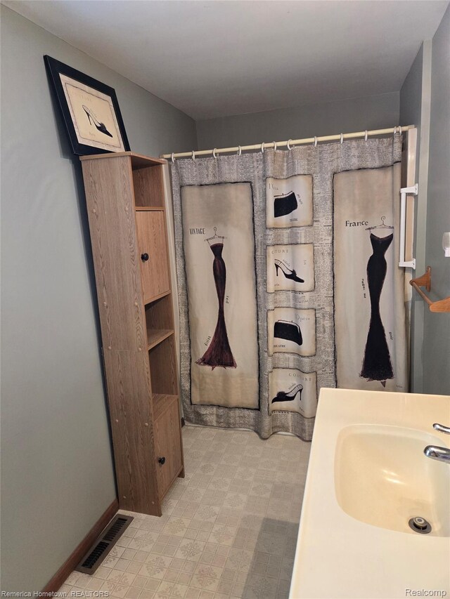 8991 Lakeview Dr, White Lake, MI 48386 - bathroom featuring a shower with shower curtain, tile patterned floors, and vanity