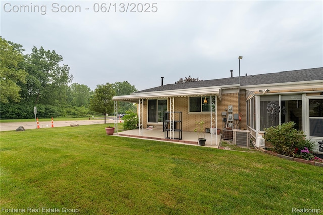 49904 Helfer Blvd, Wixom, MI 48393 - back of property with a patio area, a yard, and brick siding