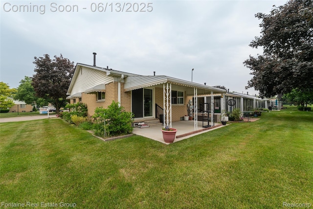 49904 Helfer Blvd, Wixom, MI 48393 - back of property with a patio, entry steps, a lawn, and brick siding