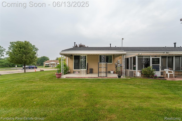 49904 Helfer Blvd, Wixom, MI 48393 - rear view of house with a patio, brick siding, a yard, and a sunroom