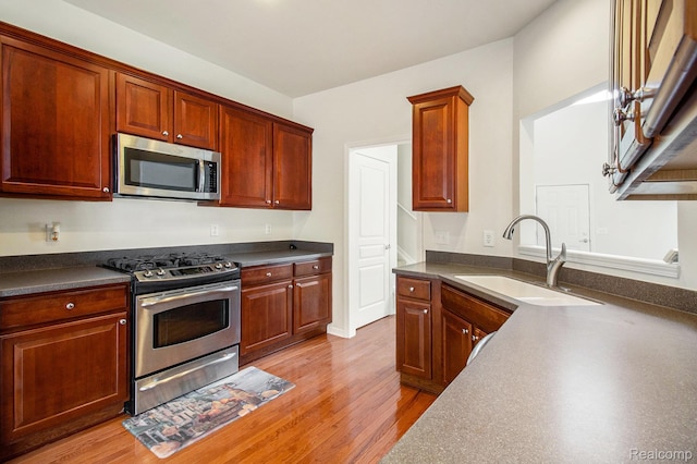 49761 Courtyard Ln, Canton, MI 48188 - kitchen featuring appliances with stainless steel finishes, dark countertops, and light wood finished floors